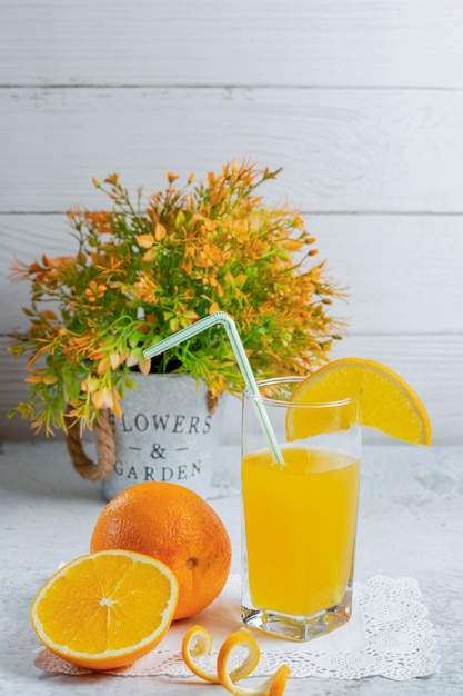 Vertikales Foto von frischen Bio-Orangen mit einem Glas Saft.