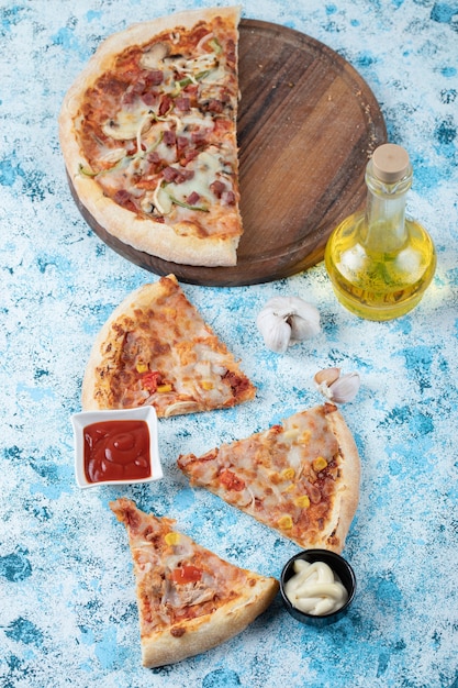 Vertikales Foto von geschnittener Pizza mit Soßen.