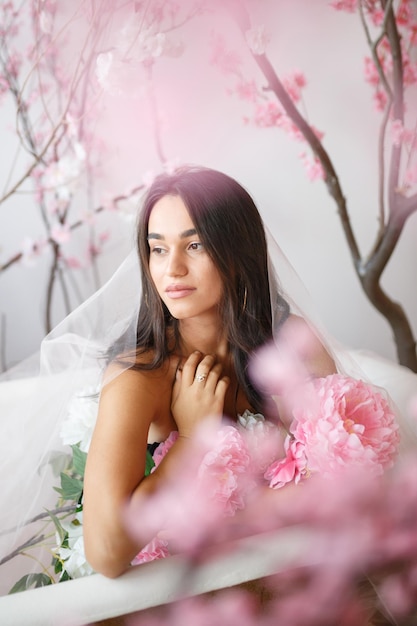 Vertikales Porträt eines jungen Mädchens mit Blumen in der Badewanne Hochwertiges Foto