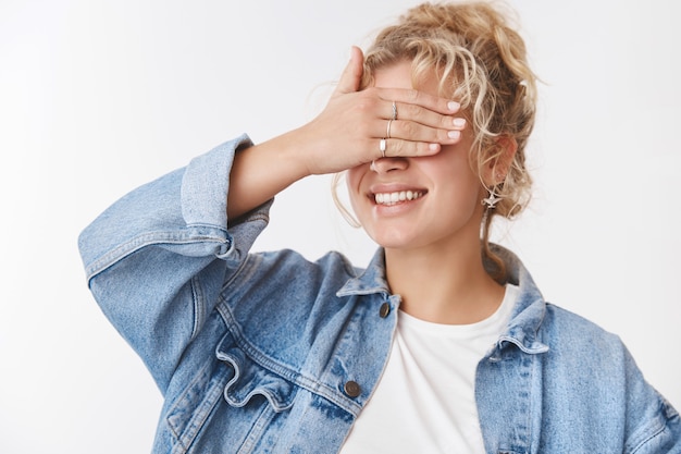 Verträumte kreative charmante süße Freundin blonde lockige Frisur stilvolle Accessoire Jeansjacke enge Augen Palme lächelnd im Allgemeinen Überraschung warten Geburtstagsgeschenk, Verstecken spielen