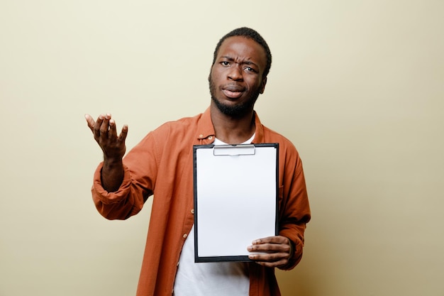 Verwirrt, sich ausbreitende Hand junger afrikanisch-amerikanischer Mann, der Klemmbrett isoliert auf weißem Hintergrund hält