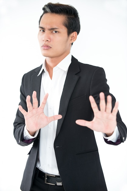 Verwirrte asiatische Geschäftsmann zeigt Stop Geste