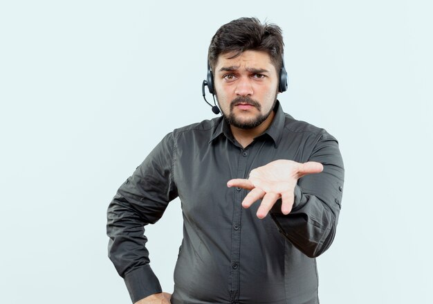 verwirrter junger Callcenter-Mann, der Headset trägt, das Hand zur Kamera heraushält