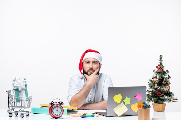 Verwirrter junger Geschäftsmann im Büro, der das neue Jahr oder die Weihnachtsarbeit feiert