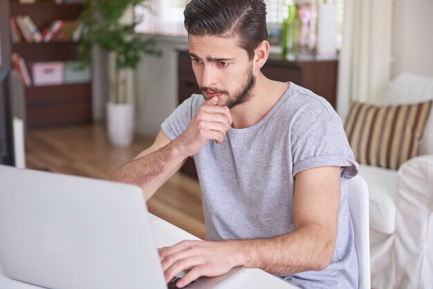Verwirrter Mann, der vor seinem Computer sitzt