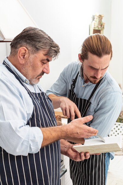 Verwirrter Vater und Sohn, die auf einem Rezept schaut