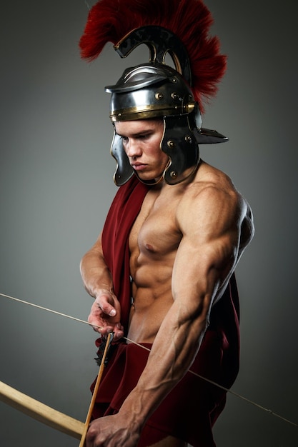 Kostenloses Foto verwundeter gladiator mit bogen isoliert auf grau.