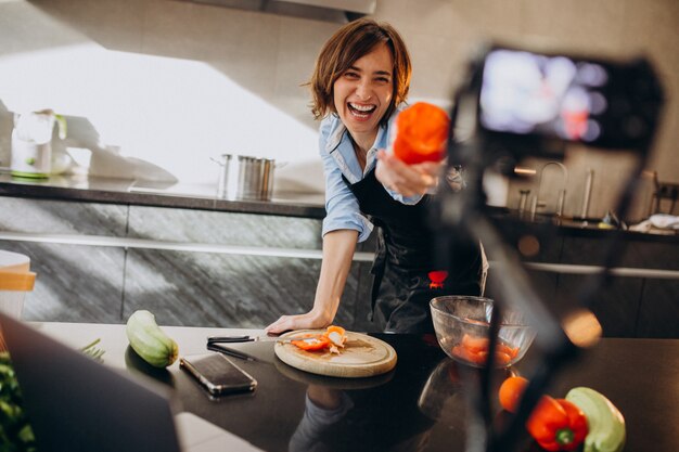 Videoblogger der jungen Frau, der an der Küche kocht und filmt