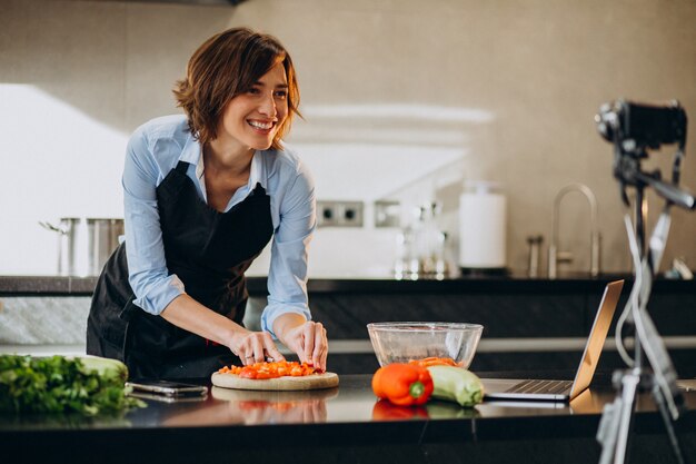 Videoblogger der jungen Frau, der an der Küche kocht und filmt