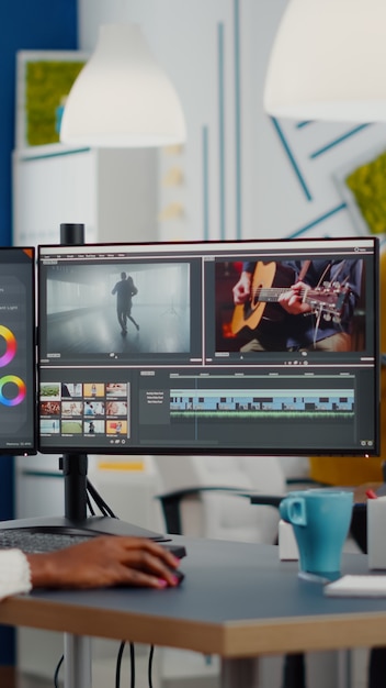 Videofilmer, der Headset-Bearbeitung von Filmen mit Postproduktionssoftware aufsetzt, die im Büro der Kreativ-Startup-Agentur arbeitet