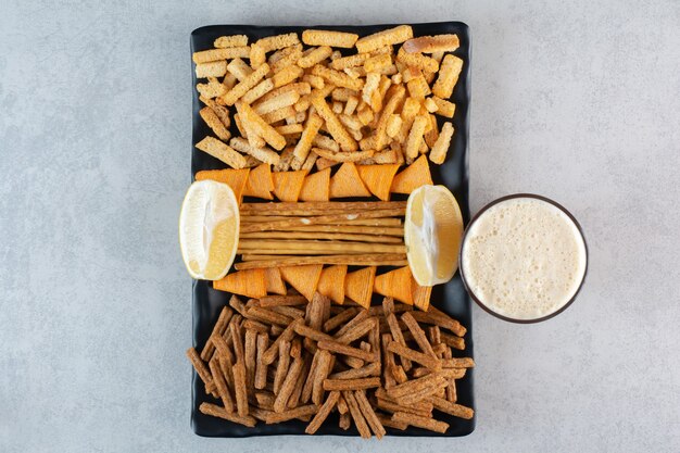 Viel leckeres Essen zum Bier auf schwarzen Tellern.