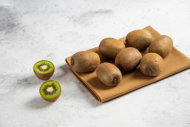 Viele frische Kiwis auf brauner Tischdecke.