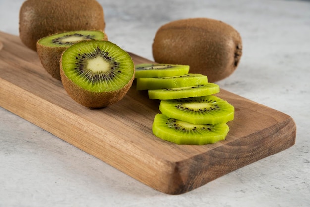 Viele Kiwis auf Holzbrett.