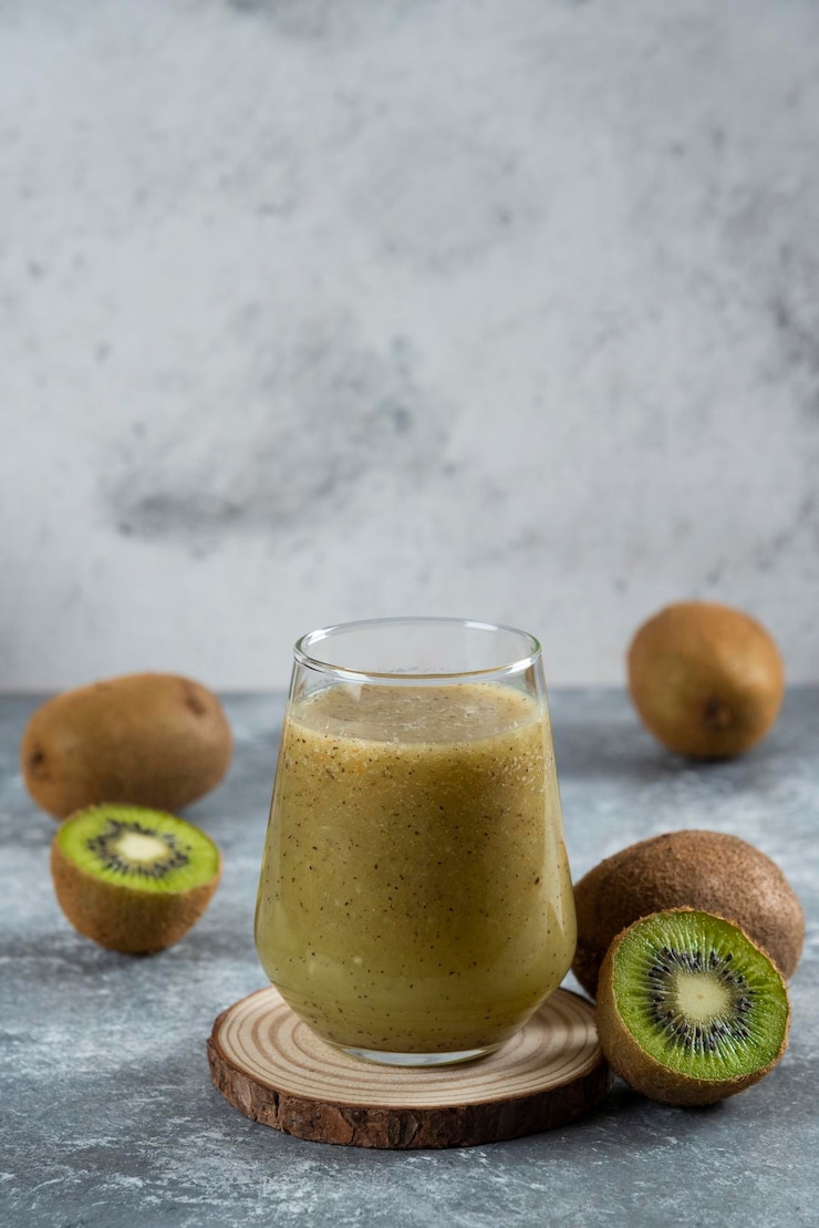 Kostenlose Foto viele kiwis mit einer glasschale saft.