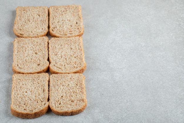 Kostenloses Foto viele scheiben schwarzbrot auf grauem hintergrund.