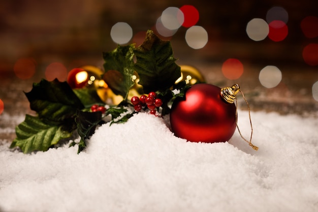 Viele Weihnachtskugeln im Schnee mit Bokeh im Hintergrund