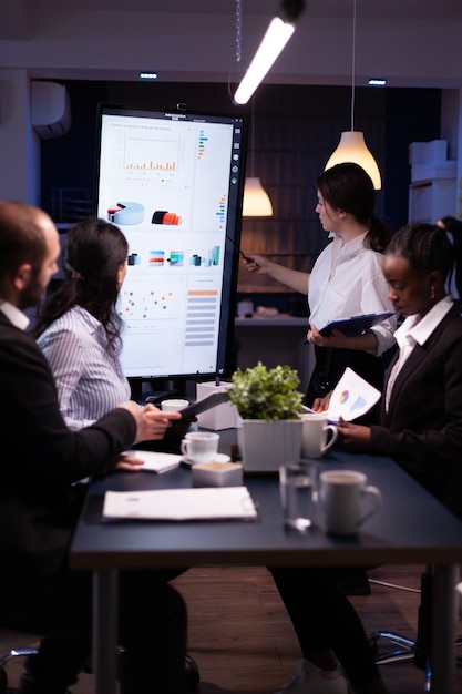 Vielfältige multiethnische Business-Teamwork-Überarbeitung im Büro-Konferenzraum bei der Analyse von Finanzdiagrammen