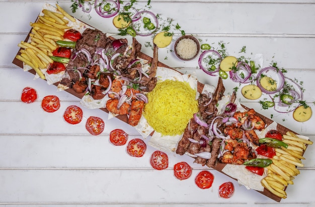 Kostenloses Foto vielzahl des fleischkebabs mit gegrilltem gemüse und salat auf der weißen tabelle