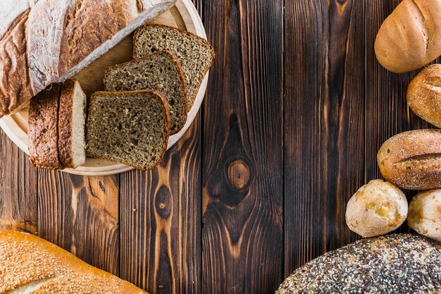 Vielzahl des frisch gebackenen Brotes auf dunklem Holztisch