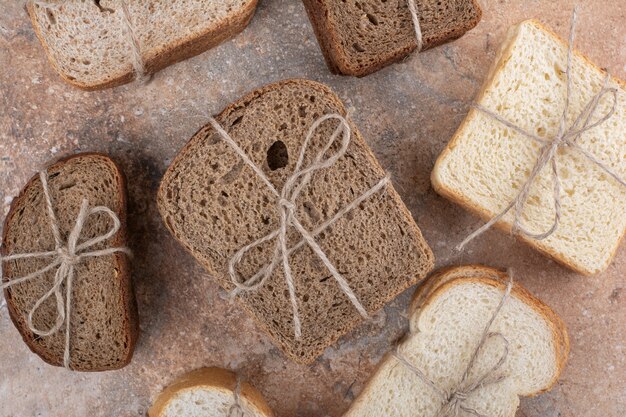 Vielzahl von Brot mit Seil auf Marmorhintergrund gebunden