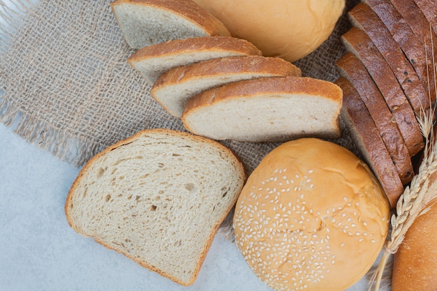 Vielzahl von hausgemachtem Brot auf Sackleinen mit Weizen. Hochwertiges Foto