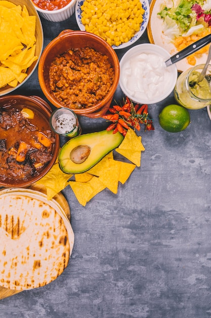 Vielzahl von leckeren mexikanischen Tellern über konkretem Hintergrund