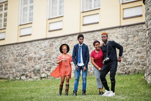 Vier afrikanische Freunde, die Spaß haben und im Freien tanzen Zwei schwarze Mädchen mit Jungs