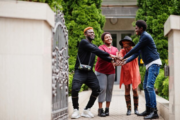 Vier afrikanische Freunde, die Spaß im Freien haben Zwei schwarze Mädchen mit Jungs