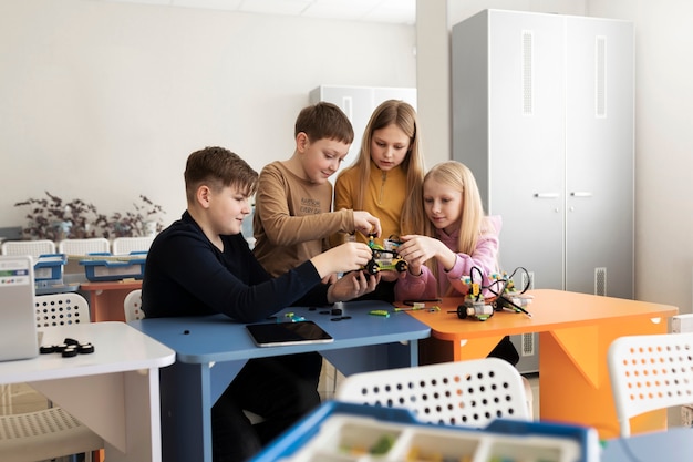 Kostenloses Foto vier kinder bauen aus elektronischen bauteilen eine drohne