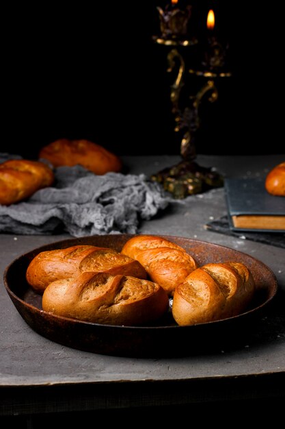 Vier kleine französische Baguettes auf eine Eisenpfanne legen