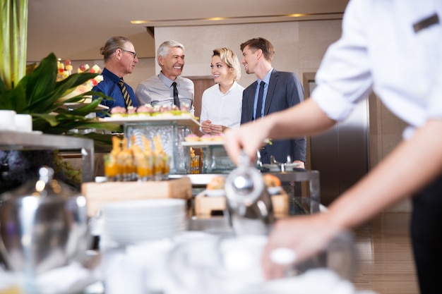 Vier Lächeln Geschäftsleute am Buffet Table