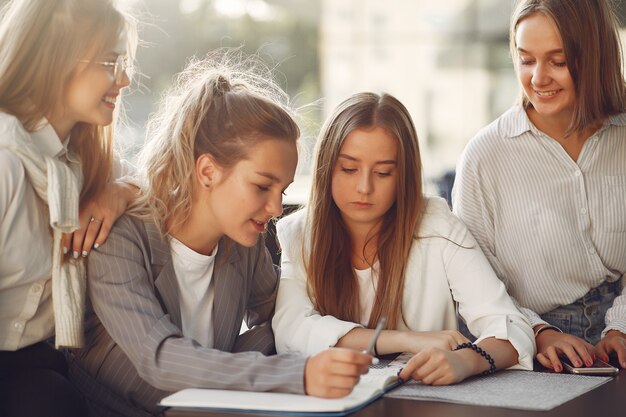 Vier Studenten auf einem Studentencampus sitzen am Tisch