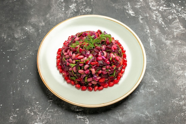 Vinaigrette-Salat der Vorderansicht mit Granatäpfeln und Bohnen auf dem dunklen Hintergrund
