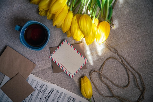 Kostenloses Foto vintage-komposition mit einer tasse tee tulpen und notizen flach gelegt