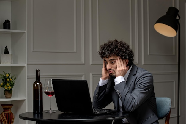 Virtuelle Liebe, hübscher, süßer Kerl im Anzug mit Wein auf einem entfernten Computerdatum, das Tempel hält