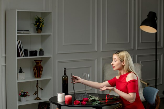 Virtuelle Liebe süßes blondes Mädchen im roten Kleid am Ferndatum mit Weinhalteschirm