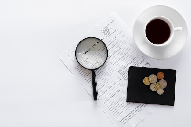 Kostenloses Foto visa-antragsformular dokumente und eine tasse kaffee auf weißem hintergrund