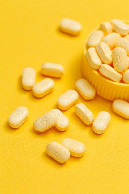 Vitamin B Tabletten auf gelbem Hintergrund