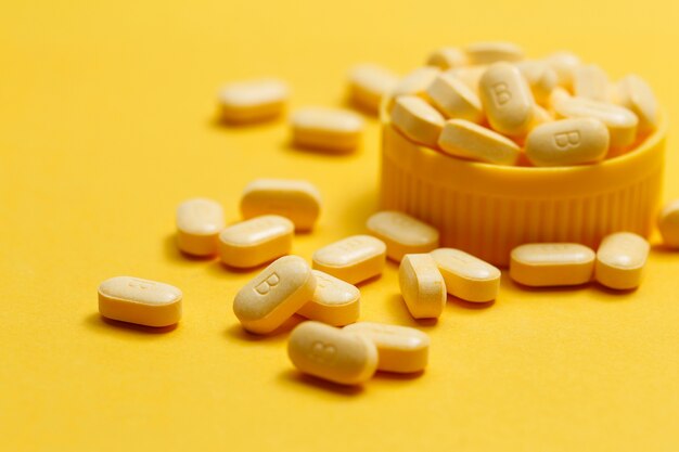 Vitamin B Tabletten auf gelbem Hintergrund