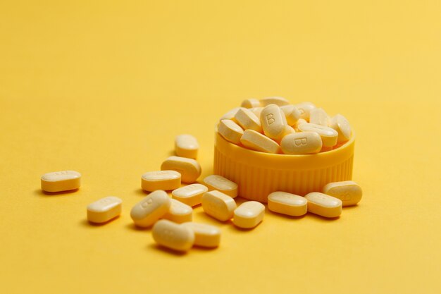 Vitamin B Tabletten auf gelbem Hintergrund