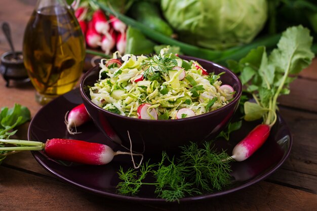 Vitaminsalat von jungem Gemüse: Kohl, Radieschen, Gurke und frische Kräuter