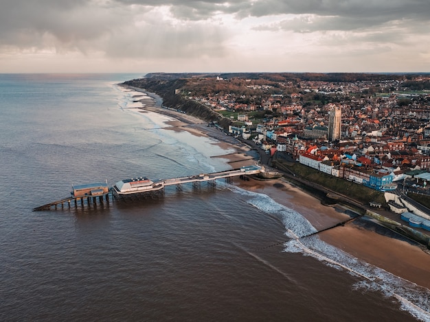 Vogelperspektive der Stadt, des öffentlichen Strandes und des Piers an einem düsteren Tag