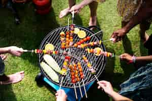 Kostenloses Foto vogelperspektive einer verschiedenen gruppe freunde, die draußen grill grillen