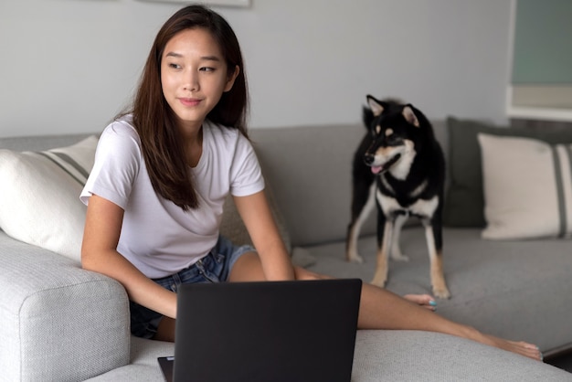 Kostenloses Foto voll erschossene frau, die auf der couch arbeitet