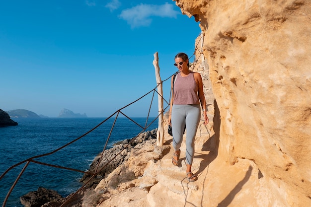 Kostenloses Foto voll erschossene frau, die auf felsen geht