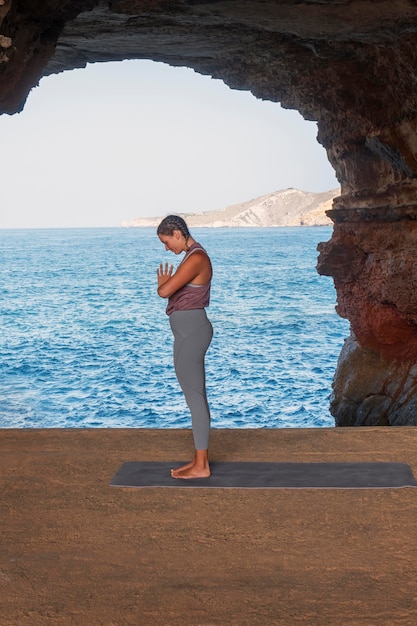 Voll erschossene Frau, die draußen Yoga macht