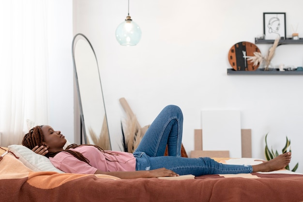 Kostenloses Foto voll erschossene frau, die im bett liegt