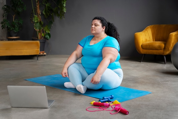 Kostenloses Foto voll erschossene frau, die im fitnessstudio trainiert