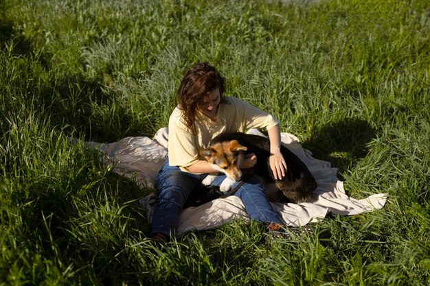 Voll erschossene Frau, die mit Hund spielt