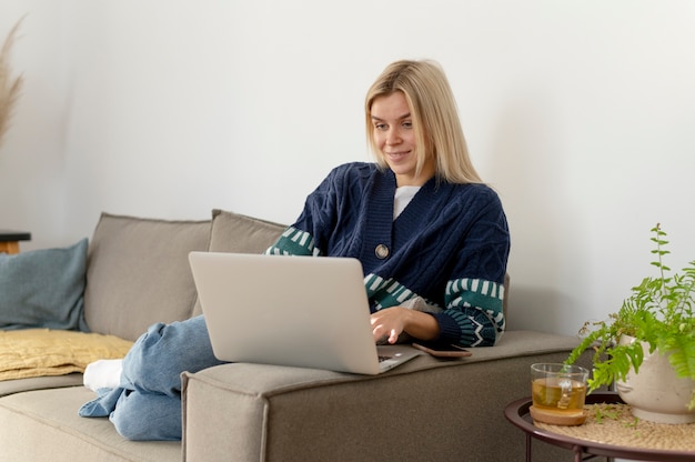 Voll erschossene Frau, die mit Laptop arbeitet